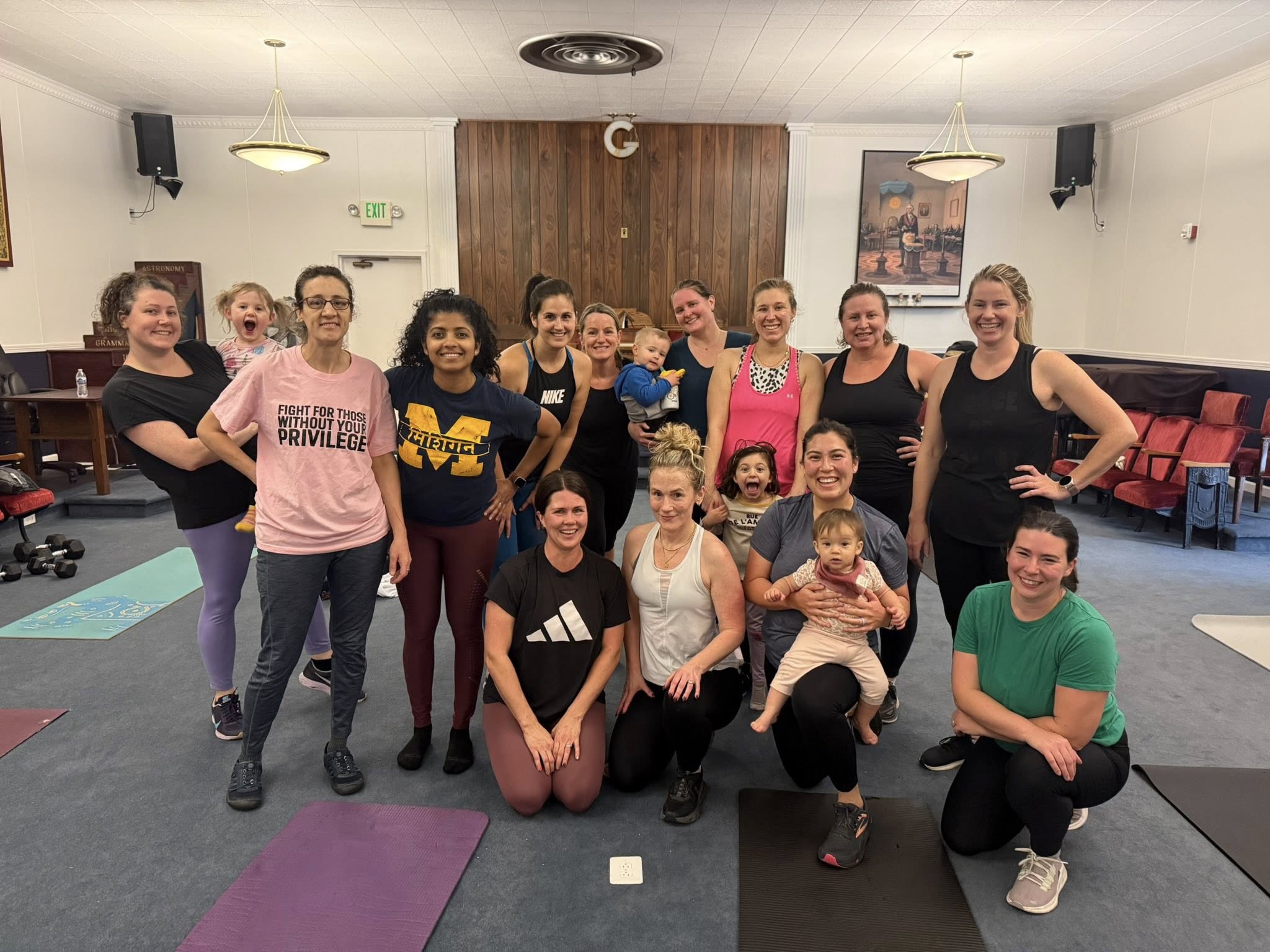 Indoor group fitness class with members and kids